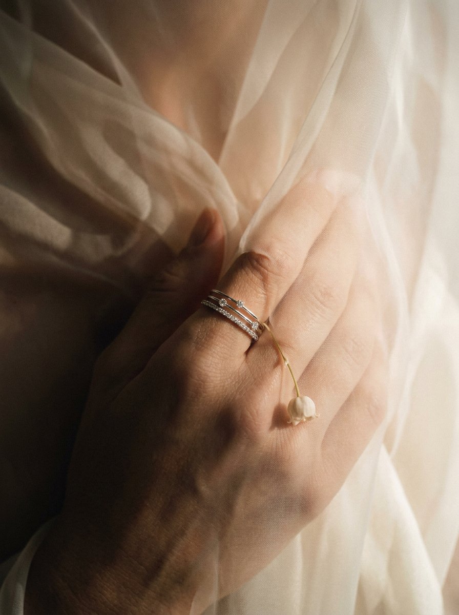 First Sight — three fine stacking rings with a single lily of the valley charm