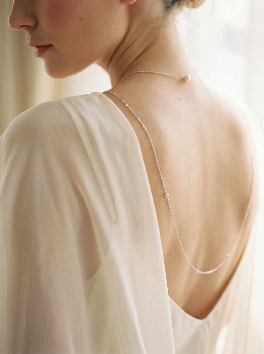 Second Glance — neck chain with one pearl and a chain slipping over the shoulder
